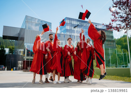 Group of cheerful university students celebrating outdoors, looking at camera, graduation concept. 138819981