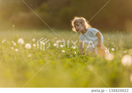 Cute girl playing on meadow, in spring nature. 138820022