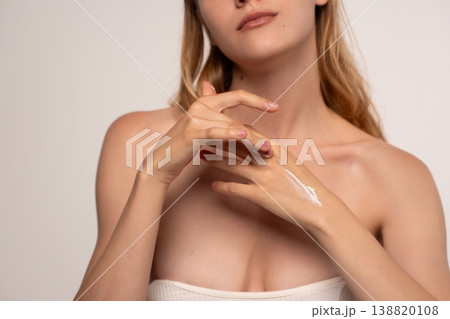 Woman applying skincare moisturizer to her hands, taking care of her skin. Concept of beauty, hydration, and wellness Woman applying skincare moisturizer to her hands, taking care of her skin. Concept of beauty, hydration, and wellness 138820108
