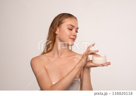 Young woman applying skincare cream, enjoying beauty routine for healthy glowing skin and wellness Young woman applying skincare cream, enjoying beauty routine for healthy glowing skin and wellness 138820118