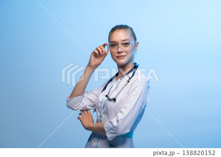 Young woman doctor wearing safety goggles and stethoscope 138820152