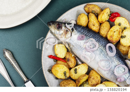 Whole salted herring with crispy potatoes and onion 138820194