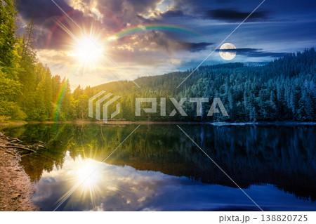 day meet night. landscape by the lake. coniferous forest near the lake and the forest mountain. epic summer solstice view of carpathian mountain reflection on synevr lake surface. harmony concept 138820725