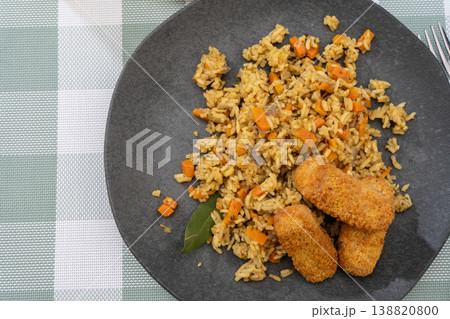 Exquisite saffron rice dish with spiced breaded and fried fish sticks 138820800