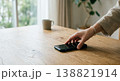 木のテーブルのスマホを手に取る瞬間 138821914