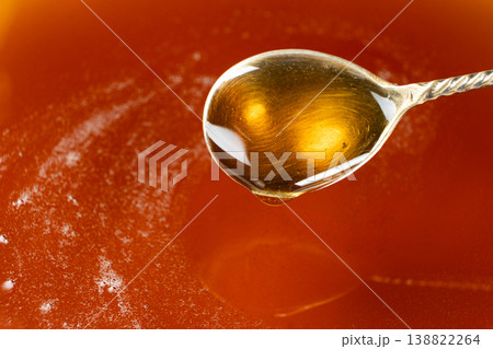 Spoon filled with golden maple syrup 138822264
