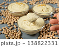 Traditional hummus in a spoon among scattered raw chickpeas. 138822331