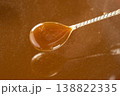 Caramel sauce in a spoon close-up, liquid caramel texture, sweet topping. 138822335