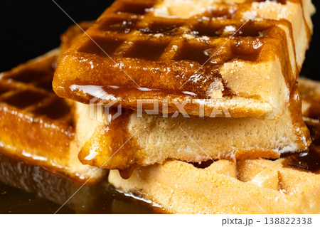 Delicious Belgian waffles topped with sweet caramel syrup close up. Delicious Belgian waffles topped with sweet caramel syrup close up. 138822338