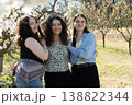 Beautiful portrait of three sisters embracing in a spring blooming garden. 138822344