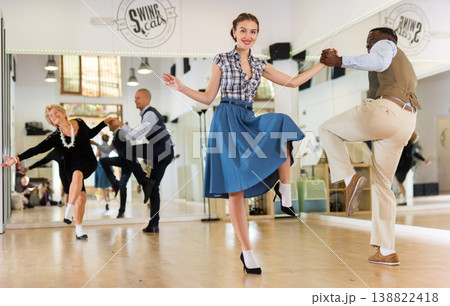 Woman with african man practising charleston dancing Woman with african man practising charleston dancing 138822418