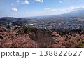 桜の花道へと続く道路と家並み、山並みが彩る春の風景 138822627