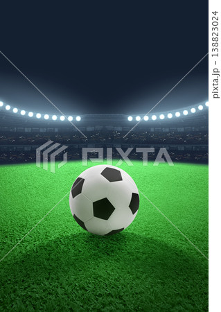 A classic black and white soccer ball sits on a vibrant green grass field in a large stadium under intense bright floodlights at night, ready for a match or championship A classic black and white soccer ball sits on a vibrant green grass field in a large stadium under intense bright floodlights at night, ready for a match or championship 138823024