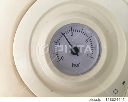 Pressure gauge shows measurement on dial, located on a machine in a workshop setting during the day Pressure gauge shows measurement on dial, located on a machine in a workshop setting during the day 138824645