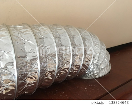 Ducting placed on a wooden surface in a room during daytime Ducting placed on a wooden surface in a room during daytime 138824648