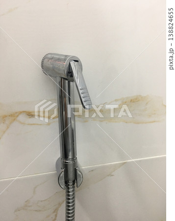 Modern faucet installed on a bathroom wall in a residential space Modern faucet installed on a bathroom wall in a residential space 138824655