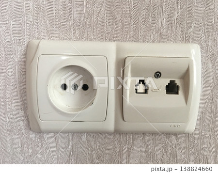 Electrical outlet and network port on a wall in a room Electrical outlet and network port on a wall in a room 138824660