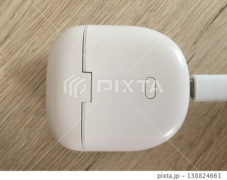 Wireless earphones charging case on wooden surface during daytime Wireless earphones charging case on wooden surface during daytime 138824661