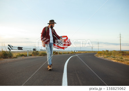 4th of July. American Flag.Patriotic holiday. Traveler with the flag of America. Beautiful sunset light. American style. 4th of July. American Flag.Patriotic holiday. Traveler with the flag of America. Beautiful sunset light. American style. 138825062