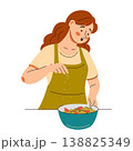 Contented woman in an apron add seasonings onto a fresh salad. Cooking scene featuring healthy food 138825349