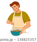 Contented man in an apron add seasonings onto a fresh salad. Cooking scene featuring healthy food 138825357