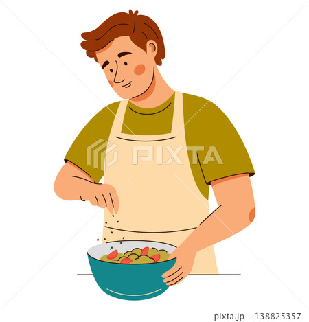 Contented man in an apron add seasonings onto a fresh salad. Cooking scene featuring healthy food 138825357