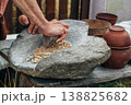 Human hand rotating an ancient stone grinding machine for smashing grains. Handmade manual equipment grind mill 138825682