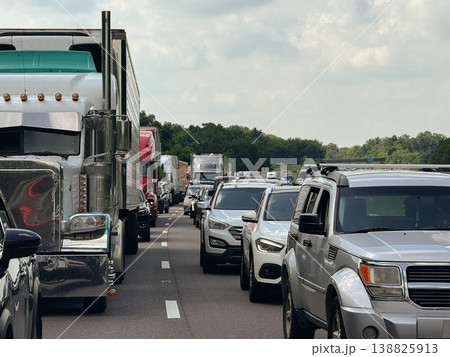 A continuous line of cars and trucks stretches across multiple lanes of roadway. The image represents modern transportation demand and real-world commuting conditions. A continuous line of cars and trucks stretches across multiple lanes of roadway. The image represents modern transportation demand and real-world commuting conditions. 138825913