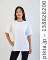 Ecommerce promotional image showcasing confident woman wearing white tshirt in studio setting 138826200