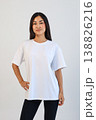 Ecommerce promotional image showcasing confident woman wearing white tshirt in studio setting 138826216