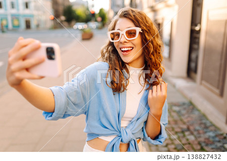 Beautiful woman traveler using phone, taking selfie, walking on the old town street. Blogging Beautiful woman traveler using phone, taking selfie, walking on the old town street. Blogging 138827432