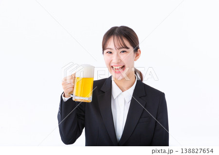 ビールで乾杯するスーツ姿の若い女性 138827654