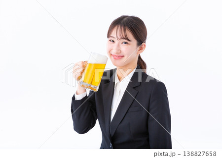 笑顔でビールを飲むスーツ姿の若い女性 138827658