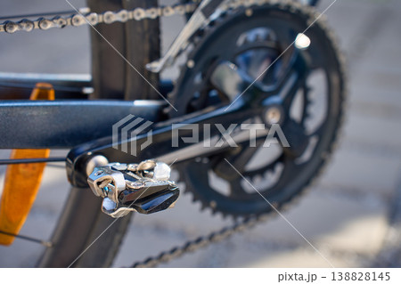 Close up of bicycle pedal on crank arm and chain on road bike Close up of bicycle pedal on crank arm and chain on road bike 138828145
