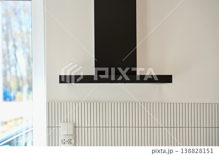 Modern black kitchen hood on wall in bright interior Modern black kitchen hood on wall in bright interior 138828151