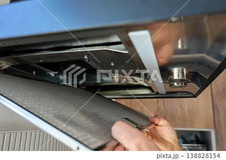 Removing filter from kitchen range hood for cleaning Removing filter from kitchen range hood for cleaning 138828154