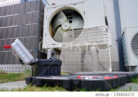 Outdoor heat pump unit opened for maintenance near house 138828172