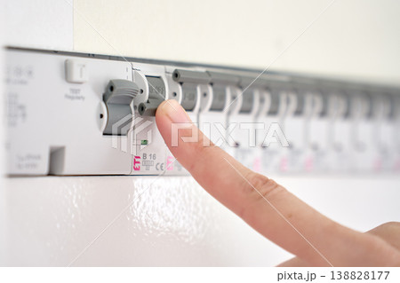 Hand switching circuit breaker in electrical distribution panel 138828177