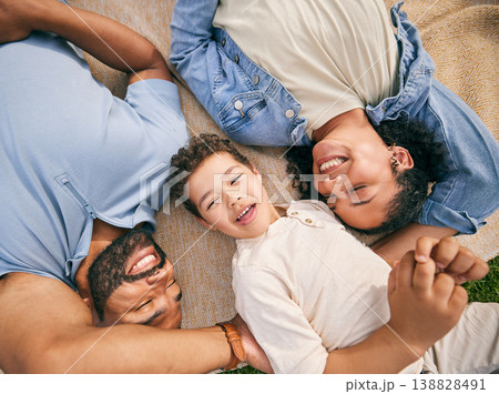 Happy family, above and relax at a park, bonding and enjoying the weekend outdoor. Top view, smile and boy child with parents on a field with freedom, love and vacation, care and chilling on lawn 138828491
