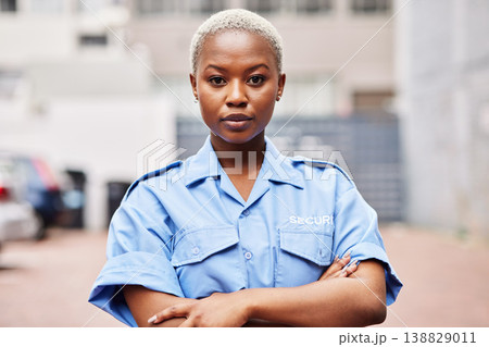 Portrait, black woman and security guard with arms crossed for surveillance service, safety and urban watch. Law enforcement, bodyguard or serious female police officer in blue shirt for city patrol Portrait, black woman and security guard with arms crossed for surveillance service, safety and urban watch. Law enforcement, bodyguard or serious female police officer in blue shirt for city patrol 138829011