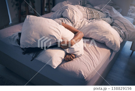 Stress, insomnia and woman with pillow on face, tired and frustrated with sleep, nightmare or dream. Fatigue, sleeping problem and exhausted girl in bed with fear, scared at night and crisis in home. 138829156