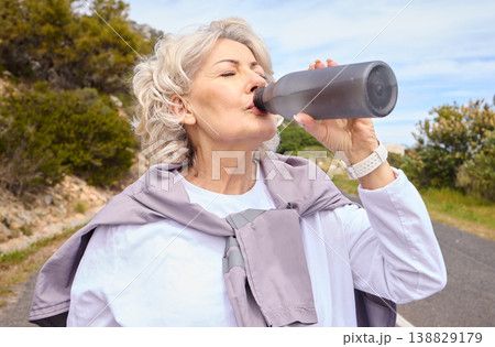 Elderly woman, drinking water and bottle on road for fitness, running or thinking for vision, hydration or health. Mature lady, runner and detox with relax for wellness, exercise or workout in nature Elderly woman, drinking water and bottle on road for fitness, running or thinking for vision, hydration or health. Mature lady, runner and detox with relax for wellness, exercise or workout in nature 138829179