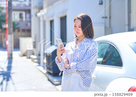屋外でスマホを見つめる日本人女性のポートレート 138829409