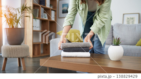 Cleaning, hands and woman with laundry in a living room for housework, routine or home spring clean. Washing, fold and female person with fresh, towels or linen in a house for household hygiene 138829429