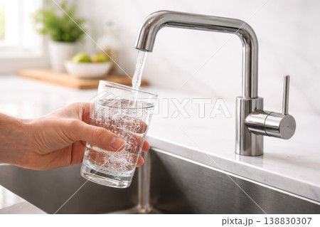 Filling glass with fresh tap water in modern kitchen hydration and healthy lifestyle concept 138830307
