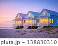 Colorful beach houses on sandy shore at sunset with cozy lights 138830310