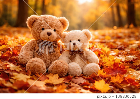 Cute bears sitting together on autumn leaves in warm golden forest light Cute bears sitting together on autumn leaves in warm golden forest light 138830329