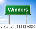 Green road sign with winners text isolated on blue sky background 138830330