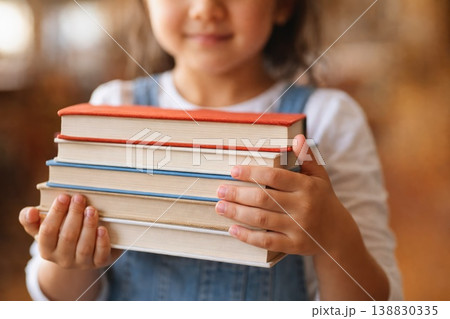 Child holding stack of books representing education learning and knowledge Child holding stack of books representing education learning and knowledge 138830335