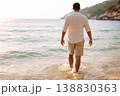 Male Tourist Entering Ocean at Warm Sunny Coastline 138830363